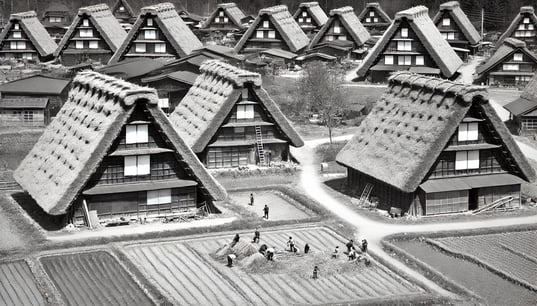 DALL?E 2024-09-30 23.11.41 - A black-and-white image in the style of an old photograph, depicting the formation of the Shirakawa-go gassho-zukuri village in the 1700s. The scene s