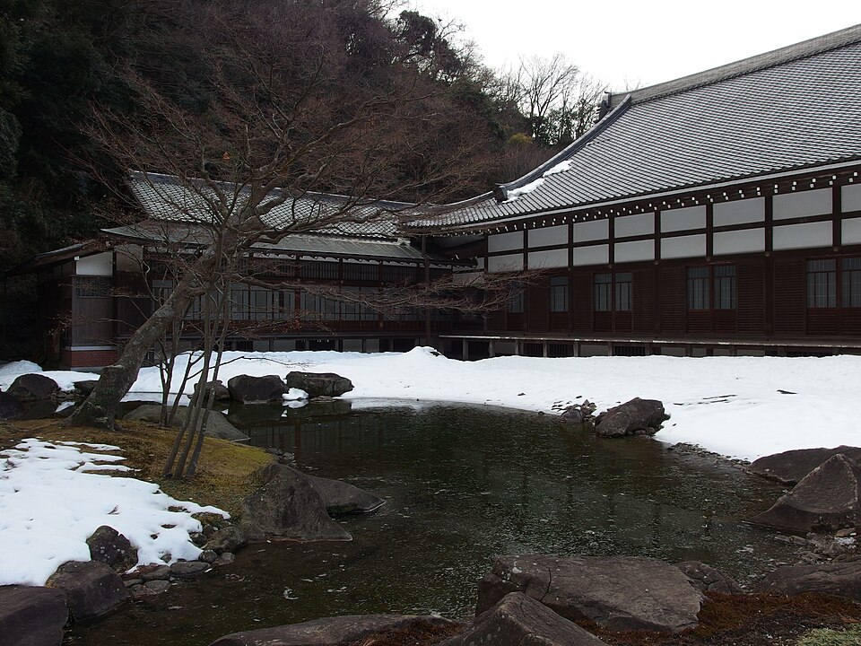 The National Treasure temple bell and bell tower of Engaku-ji, a full view of the bell tower standing among green trees